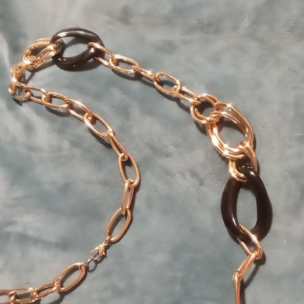 Long link curb chain with black resin link accents . In gold tone 34 inches long